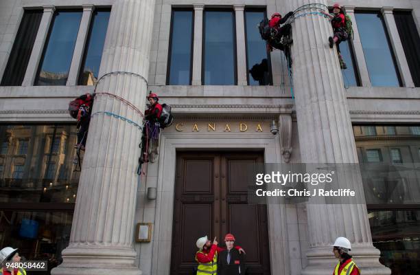 Greenpeace activists stand with a carboard cutout of Justin Trudeau and build a wood and card 'oil pipeline' outside the Canadian High Commission,...