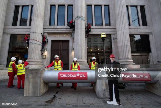 Greenpeace activists build a wood and card 'oil pipeline' outside the Canadian High Commission, Canada House, to protest against the Trudeau...