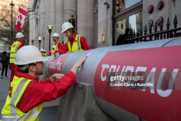 Greenpeace activists build a wood and card 'oil pipeline' outside the Canadian High Commission, Canada House, to protest against the Trudeau...