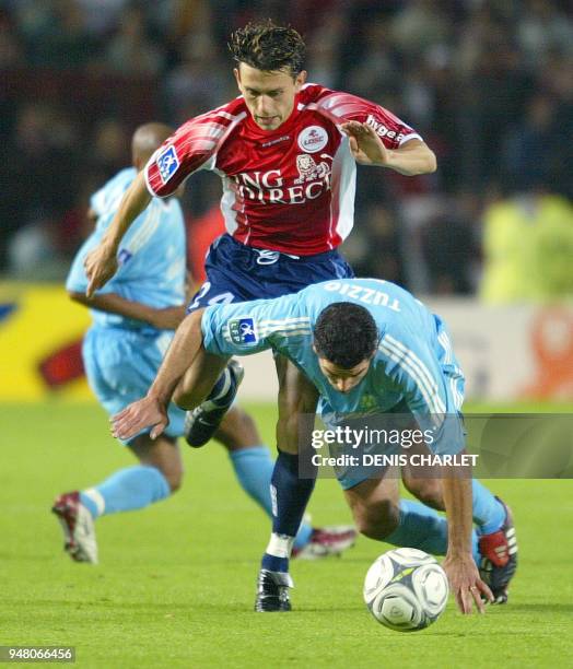 Le milieu de terrain lillois Christophe Landrin est à la lutte avec l'Argentin Eduardo Nicolas Tuzzio de l'OM, le 05 octobre 2002 lors de la...