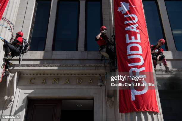 Greenpeace activists drink tea as they unfurl banners after building a wood and card 'oil pipeline' outside the Canadian High Commission, Canada...