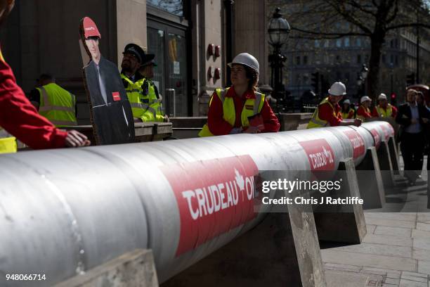 Greenpeace activists build a wood and card 'oil pipeline' outside the Canadian High Commission, Canada House, to protest against the Trudeau...