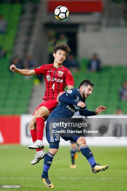 Wang Shenchao of Shanghai heads the ball over Christian Theoharous of the Victory during the AFC Champions League match between Melbourne Victory and...