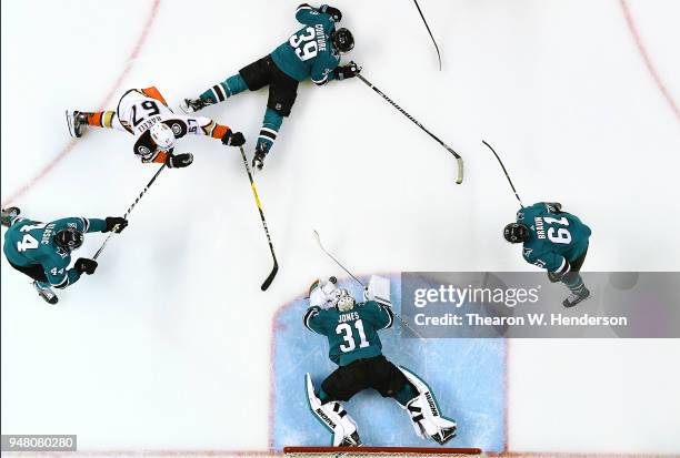 Goalie Martin Jones, Justin Braun, Logan Couture and Marc-Edouard Vlasic of the San Jose Sharks defends the goal against Rickard Rakell of the...