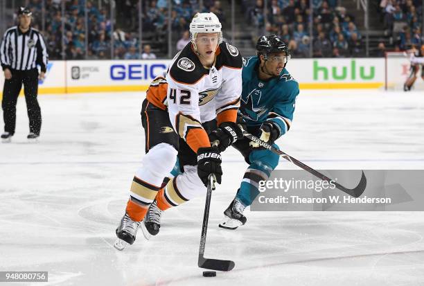 Josh Manson of the Anaheim Ducks skates up ice with control of the puck pursued by Evander Kane of the San Jose Sharks during the third period in...