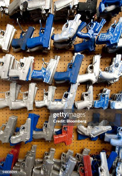 Exact molds of various guns used for fitting holsters hang at the D.M. Bullard Leather manufacturing shop in Azle, Texas, U.S., on Thursday, Dec....