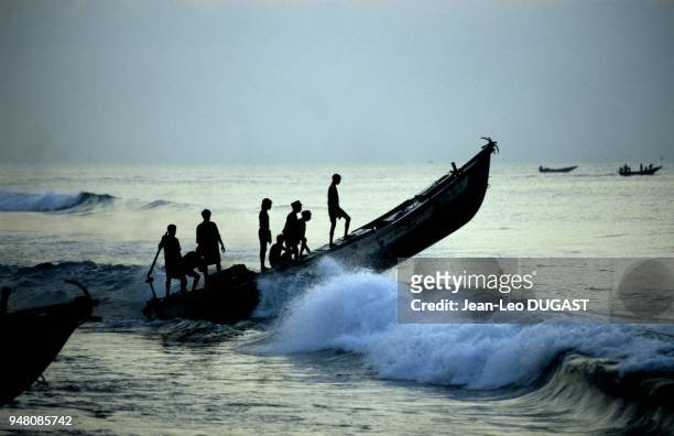 Un équipage de pêcheurs part en mer à bord d'un bateau en fibre de verre motorisé. Un équipage de pêcheurs part en mer à bord d'un bateau en fibre de...