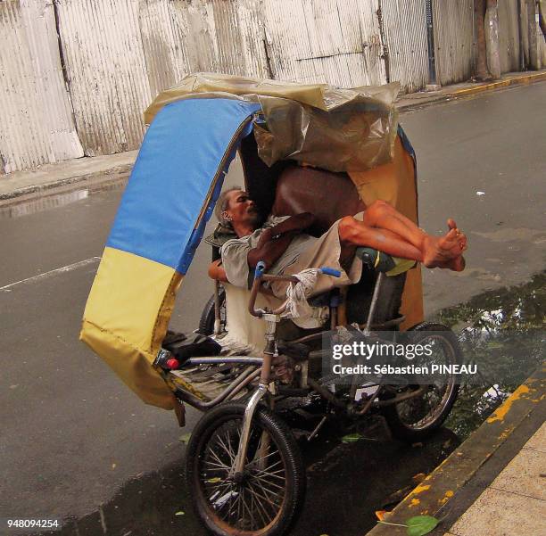 Homme dormant sur un vélo à Manille dans le quartier d'Ermita , Philippines.