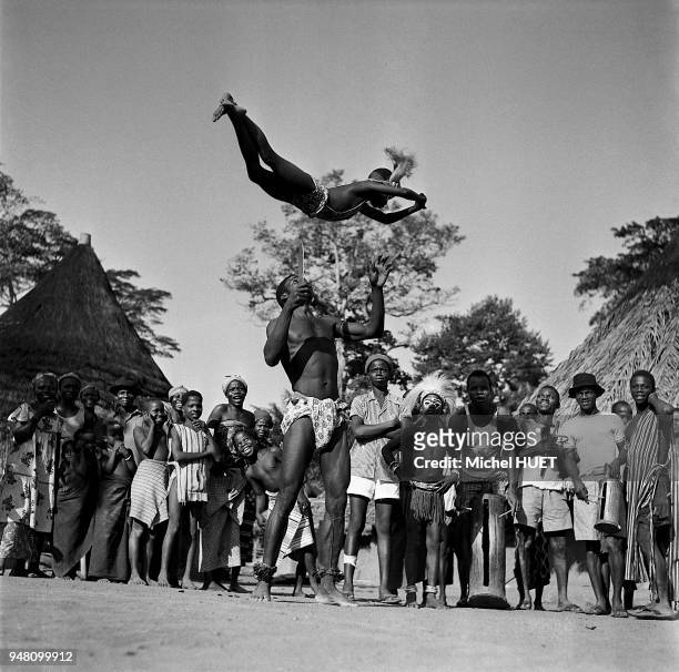 Un danseur Yacouba fait mine de recevoir une fillette sur la pointe de son couteau lors de la danse du Simbo en Côte d'Ivoire vers 1950-1960. La...