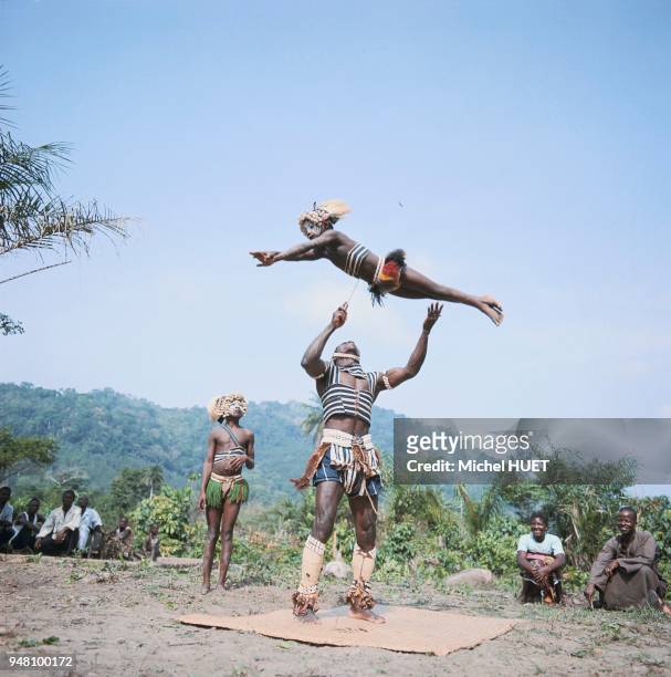 Un danseur Yacouba fait mine de recevoir une fillette sur la pointe de son couteau lors de la danse du Simbo en Côte d'Ivoire vers 1950-1960. La...