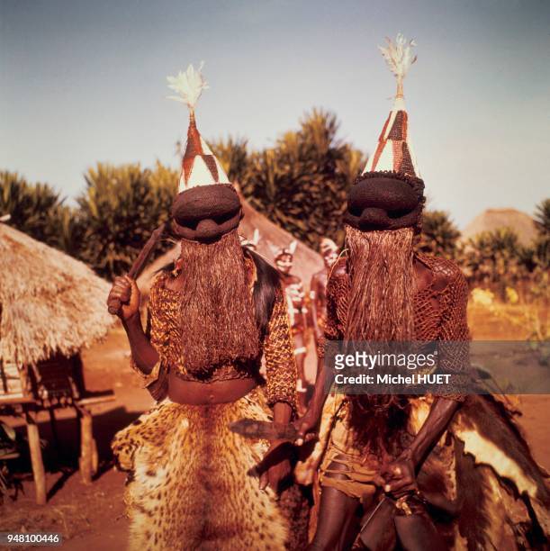 Deux guerriers salampasu portent des masques de la danse mfuku dans la région de Luiza au Zaïre vers 1950-1960. Le masque est complété par une...