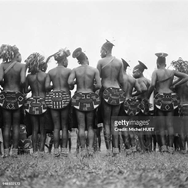 Des femmes mangbetu, habillées de leur typique cache-fesses negebe en écorce battue et orné de formes géométriques, se tiennent en groupe dans la...
