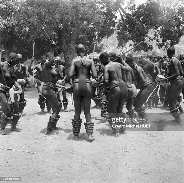 Des femmes offrent la bouillie de mil sur les pierres consacrées lors du rite appelé Leuru Benleng dans une société Fali au Cameroun vers 1950-1953....