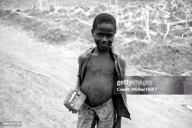 Enfant porte un jouet qui représente un poste de radio. L'enfant porte un jouet qui représente un poste de radio.