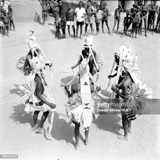 Des filles Sénoufo terminent leur initiation lors d'une fête et se parent de coiffes de cauris à Boundiali en Côte d'Ivoire au début des années 1950....