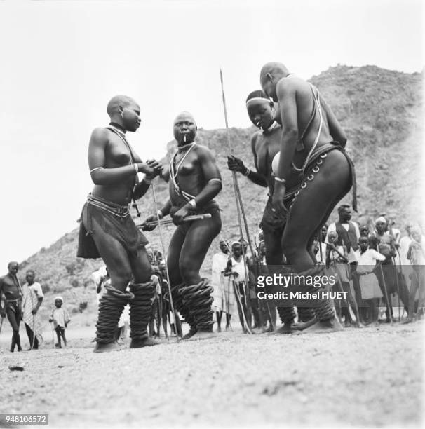 Des femmes offrent la bouillie de mil sur les pierres consacrées lors du rite appelé Leuru Benleng dans une société Fali au Cameroun vers 1950-1953....