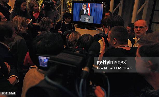 Journalists listen to US President Barack Obama talking from the airport on the final day of the UN Climate Change Conference on December 18 , 2009...