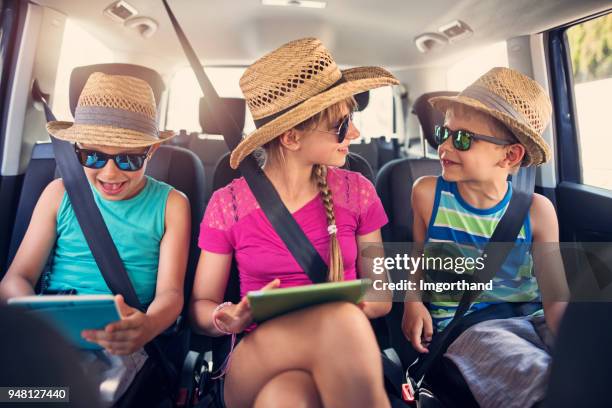 kinder spielen mit tabletten während der autofahrt. - girl in car with ipad stock-fotos und bilder