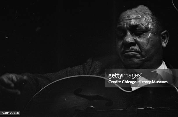 American Blues musician Big Joe Williams plays guitar as he performs onstage at the Folklife Festival, Chicago, Illinois, 1961.