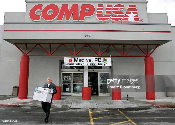 Customer walks out of a CompUSA store in Orem, Utah on Wednesday, April 5 as a sign reading "Mac vs. PC" is seen hanging out front. Apple introduced...