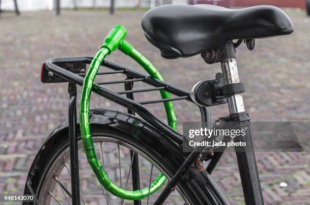 black dutch ladies bike locked - gepäckablage stock-fotos und bilder