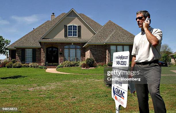 Realtor Greg Ryan talk on his cell phone while on the grounds of a property listed through GMAC Real Estate in Bossier City, Louisiana, Monday, April...