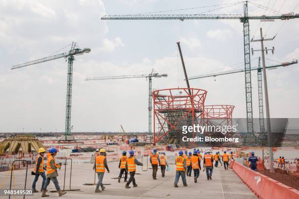 Workers pass in front of a terminal under construction at the New International Airport of Mexico City in Texcoco, Mexico, on Friday, April 13, 2018....