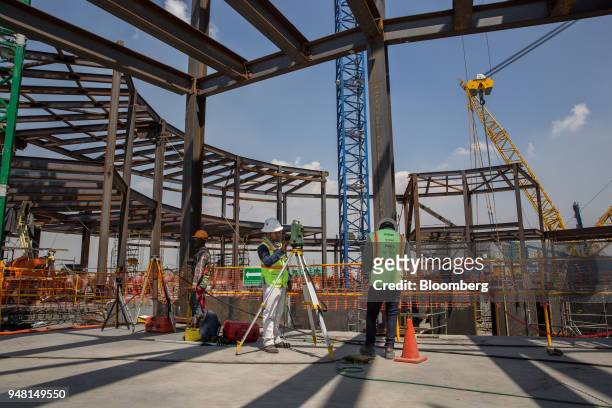 Worker uses a theodolite to survey the site of the control tower under construction at the New International Airport of Mexico City in Texcoco,...