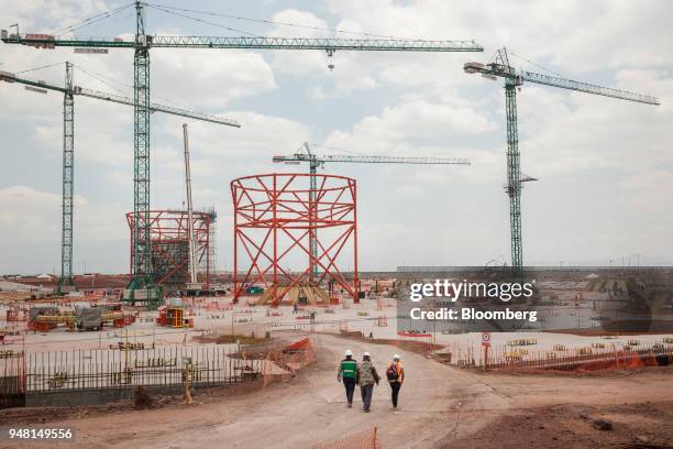 Workers pass in front of a terminal under construction at the New International Airport of Mexico City in Texcoco, Mexico, on Friday, April 13, 2018....