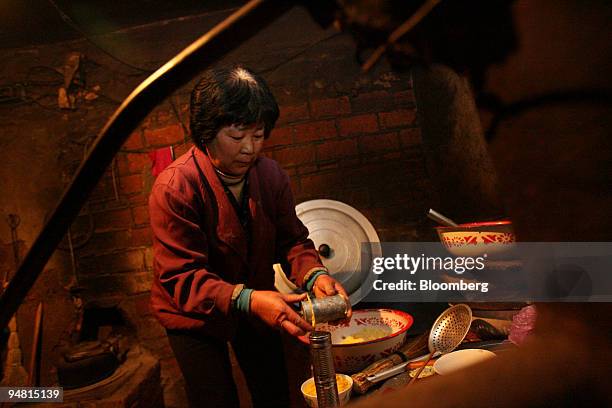 Farmer Cong Peiling prepares noodles on a stove in her two-room mud house in Yongfu village, 200 km North East of Jiamusi city and 150 km from the...