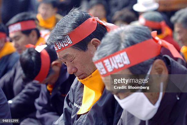 South Korean farmers bow their heads while listening to a speaker during a protest against importing U.S. Rice for direct sale in Icheon, South Korea...