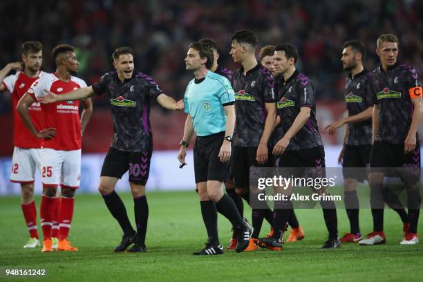 Referee Guido Winkmann discusses with players of Freiburg after a hand penalty decision after the half time whistle during the Bundesliga match...