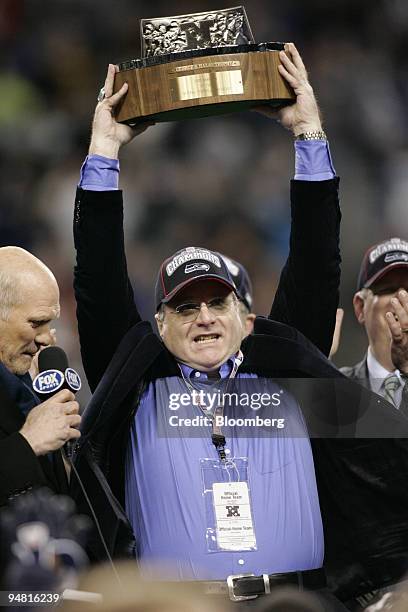 Seattle Seahawks owner Paul Allen hoists the NFC Championship trophy after his team defeated the Carolina Panthers 34-14 in the NFL's NFC...