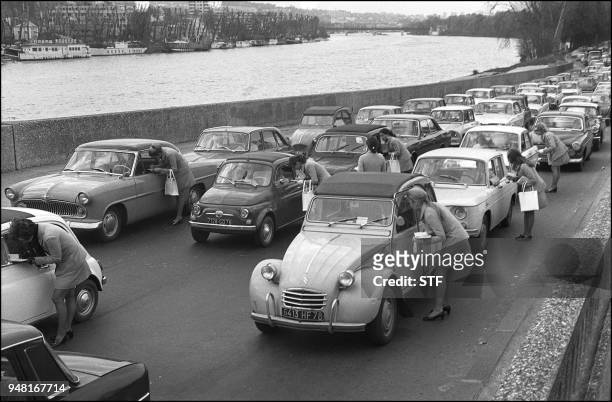 Photo datée du 19 avril 1969 de jeunes femmes profitant d'un bouchon sur les quais de la Seine à Paris pour effectuer une enquête auprès des...