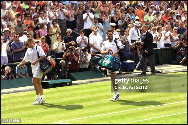 Wimbledon, uk july 6, 2001 semi final winner pat rafter smiles to his coach tony roche and girlfriend lara feldham as he walks off the center court...