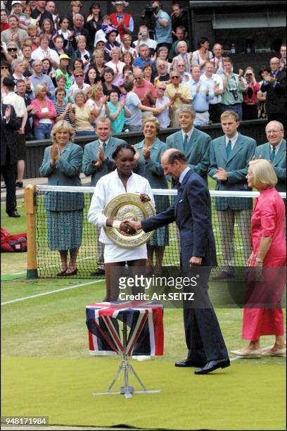 Wimbledon, uk july 8, 2001 venus williams shaking hands with the duke of kent, as the duchess of kent observes.