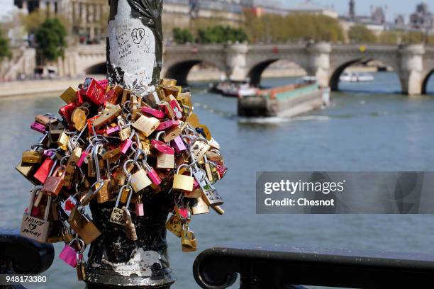 Love padlocks hung on a street lamp are seen on the "Pont des Arts" on April 18, 2018 in Paris, France. Paris city hall has replaced the fences...