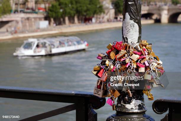 Love padlocks hung on a street lamp are seen on the "Pont des Arts" on April 18, 2018 in Paris, France. Paris city hall has replaced the fences...