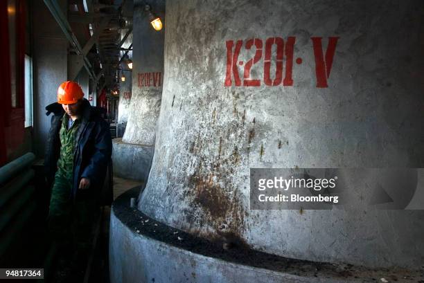 Worker passes a condenser at one of the OAO Gazprom refineries in Urengoy, Siberia, Russia, Wednesday, June 2, 2004.