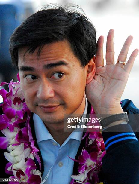 The leader of Thailand's Democrats party, Abhisit Vejjajiva, strains to listen before his speech at a mass rally in Bangkok on Friday March 24, 2006....