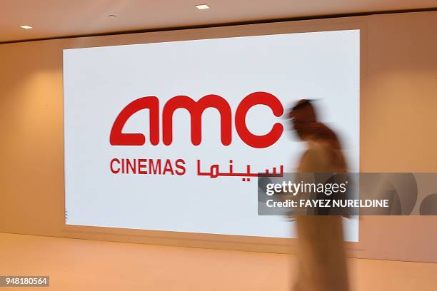 Saudi man walks past the AMC logo during a cinema test screening in Riyadh on April 18, 2018. - Blockbuster action flick "Black Panther" play at a...