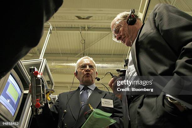 Sten-Ake Aronsson, left, senior vice president of Volvo Powertrain, shows an engine computer module to U.S. Secretary of the Treasury John Snow, as...