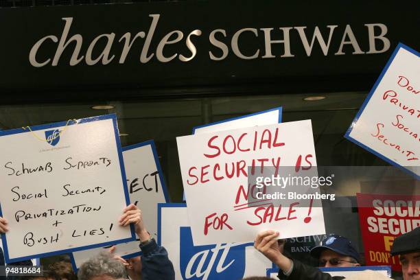 Demonstrations against President Bush's Social Security plan hold signs in front of the Charles Schwab K Street office in Washington, DC on March 31,...
