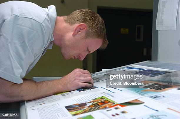 Frotscher Druckerei employee uses a lupe to check the color on a sheet he has just printed from a new Heidelberg Speedmaster printing press in...