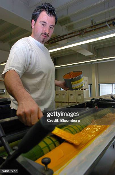 Frotscher Druckerei employee Michael Manz applies yellow ink to the rollers in a Heidelberg printing press in Darmstadt, Germany, Monday, April 4,...