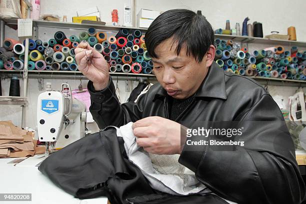 Tailor Hu Renfei makes a woolen suit in Beijing, China, on January 16, 2005. Wool growers in Australia are enlisting movie star Yin Xiaotian to...