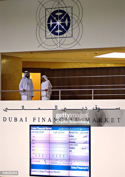 Two men are pictured on a balcony overlooking the trading floor of the Dubai Financial Market, in the Dubai World Trade Centre in Dubai, United Arab...