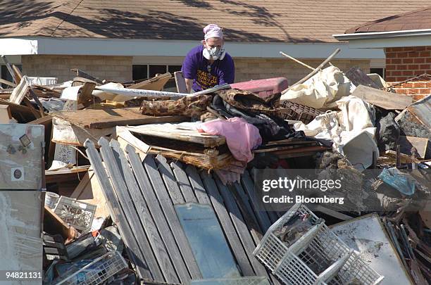 Virginia Commonwealth University freshman Alexis Richards climbs on top of a pile of debris almost as high as a single story home during volunteer...