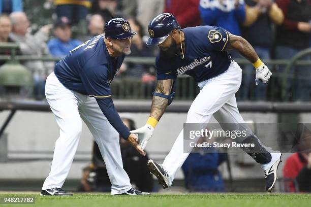 Eric Thames of the Milwaukee Brewers is congratulated by third base coach Ed Sedar following a two-run home run against the Cincinnati Reds during...