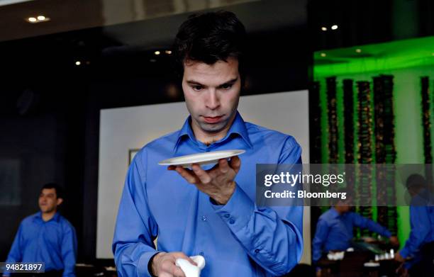 Mario Hernandez looks over a bread plate as he prepares the dining room for dinner at A Voce, Friday, March 17, 2006 in New York.